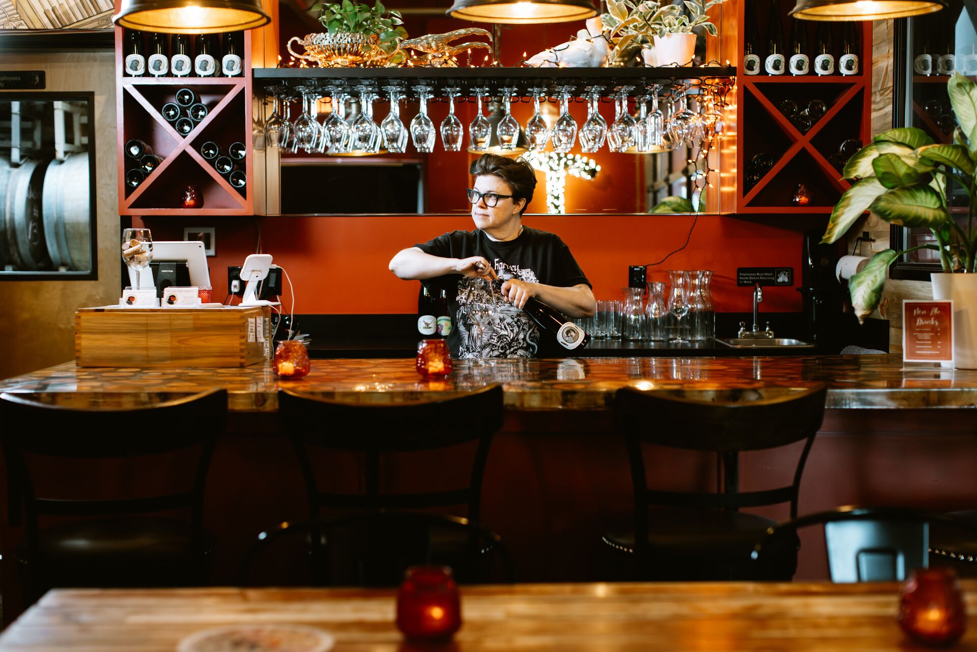 A bartender opening a bottle of wine behind the tasting room bar